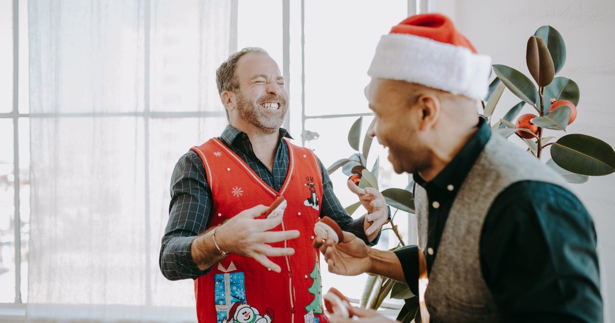 Two friends enjoying a Christmas celebration, wearing festive attire indoors.