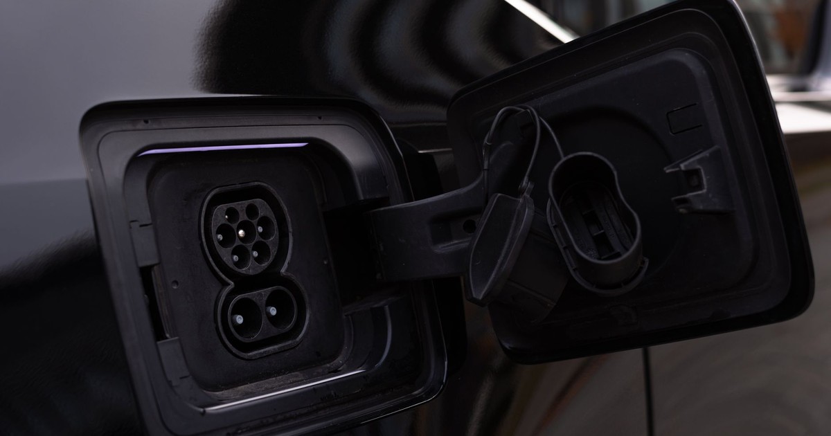 Close-up image of an electric vehicle charging port on a black car.