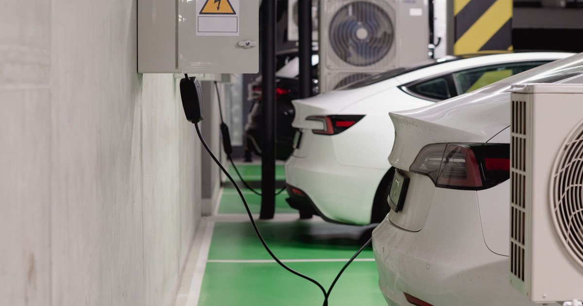 Electric vehicles charging at an indoor station in a modern underground garage.