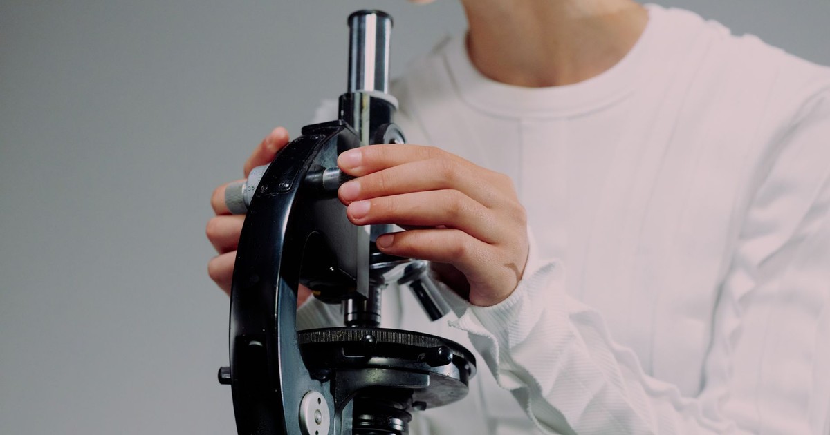 Scientist carefully using a microscope for research, close-up shot.
