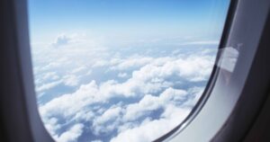 The 10 Longest Airplane Flights on Earth Right Now (and One Coming in 2027) Breathtaking view of clouds and blue sky through an airplane window during flight.