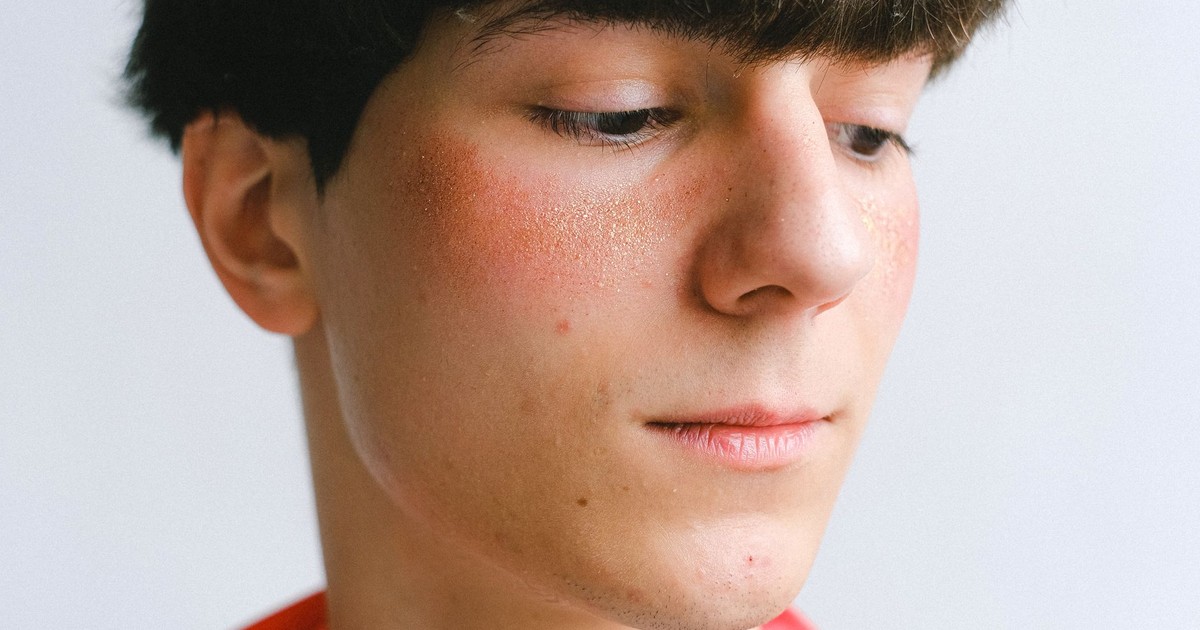 Portrait of a young man with freckles in a soft light setting.