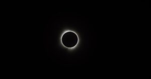 Three Cosmic Events Will Align Next Week, Fueling 'Doomsday' Speculation Online Captivating image of a solar eclipse showcasing the moon's silhouette against the sun's corona.