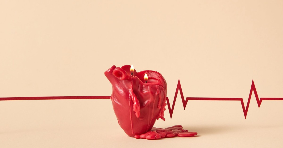 Creative heart-shaped candle melting with lit flames, against a backdrop of an ECG line symbolizing heartbeat.