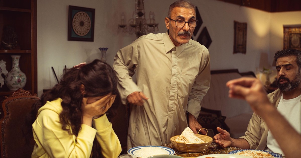 A family gathered around a dining table having an intense emotional exchange.