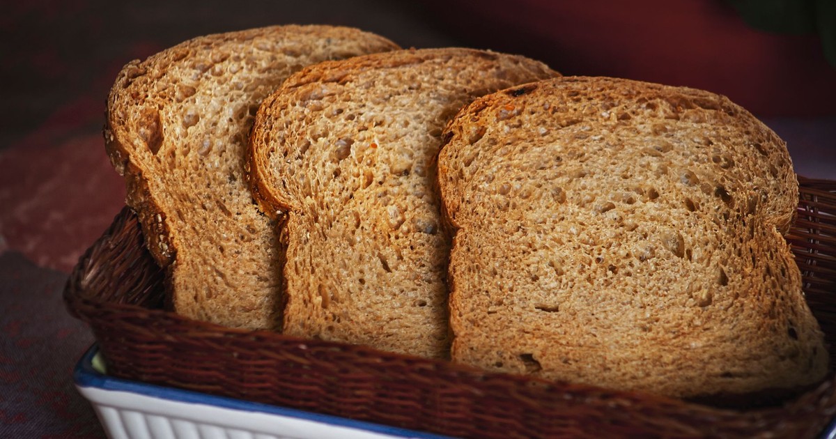 Three slices of toasted brown bread arranged in a woven basket, perfect for a breakfast scene.